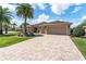 Beautiful home featuring a paver driveway, lush lawn, and well-maintained landscaping at 630 Laurel Run, The Villages, FL 32162