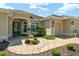 Beautiful home showcasing a beige exterior, green front door, manicured landscaping, and paver walkway at 630 Laurel Run, The Villages, FL 32162