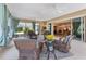 Spacious lanai with multiple seating areas, ceiling fans, and sliding glass door to interior at 630 Laurel Run, The Villages, FL 32162