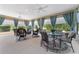 Spacious lanai with multiple seating areas, ceiling fans, curtains, and views of the backyard at 630 Laurel Run, The Villages, FL 32162