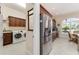 Modern laundry room with stainless steel washer and dryer, granite counters and wooden cabinets at 630 Laurel Run, The Villages, FL 32162
