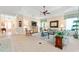 Open living space with wood floors, comfortable couches, entertainment center, and a ceiling fan at 630 Laurel Run, The Villages, FL 32162