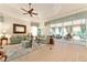 Cozy living room featuring light-colored wood floors, comfortable seating, and a sliding glass door at 630 Laurel Run, The Villages, FL 32162
