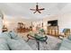 Open-concept living and dining area with light wood floors, comfortable seating, and a large television at 630 Laurel Run, The Villages, FL 32162