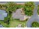An aerial view of a home featuring a well-maintained roof, lush landscaping, and a driveway at 725 Beldon Ct, The Villages, FL 32162