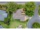 An aerial view of a home featuring a well-maintained roof, lush landscaping, and a driveway at 725 Beldon Ct, The Villages, FL 32162