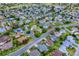 Wide aerial shot of a residential neighborhood featuring lush landscaping, mature trees, and a golf course at 725 Beldon Ct, The Villages, FL 32162