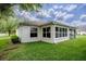 Lush backyard with well-maintained lawn and view of the home's exterior at 725 Beldon Ct, The Villages, FL 32162