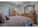 Comfortable bedroom with an ornate mirror and dresser set with a ceiling fan at 725 Beldon Ct, The Villages, FL 32162