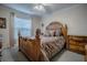 Bedroom with a natural wood bed frame, patterned bedding, and traditional decor at 725 Beldon Ct, The Villages, FL 32162