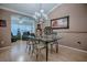 Stylish dining area featuring a glass table, modern chandelier, and an open view to the living area at 725 Beldon Ct, The Villages, FL 32162