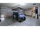 Spacious garage featuring a golf cart, ample storage, and a clean floor at 725 Beldon Ct, The Villages, FL 32162