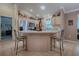 Bright kitchen with wood cabinets, stainless steel appliances, island with seating, and decorative accents above cabinets at 725 Beldon Ct, The Villages, FL 32162