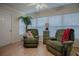 Well-lit living room featuring two recliners, a decorative plant, and window blinds for privacy at 725 Beldon Ct, The Villages, FL 32162