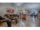 Open-concept living area featuring hardwood floors, a comfortable sofa, and a seamless flow to the kitchen at 725 Beldon Ct, The Villages, FL 32162
