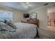 Well-lit primary bedroom featuring a wood dresser, TV, and doorway into another room at 725 Beldon Ct, The Villages, FL 32162