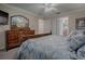 Comfortable primary bedroom featuring a wood dresser, a doorway to the primary bathroom, and ample closet space at 725 Beldon Ct, The Villages, FL 32162