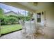 Relaxing screened patio with wicker furniture and a view of the landscaped yard at 725 Beldon Ct, The Villages, FL 32162
