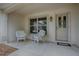 Cozy front porch featuring white wicker furniture, a decorative door, and a welcoming ambiance at 725 Beldon Ct, The Villages, FL 32162