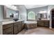Luxury bathroom with dual sinks, a soaking tub, and elegant tile details at 7973 Lake Nellie Rd, Clermont, FL 34714