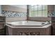 Bathroom featuring a corner soaking tub with a large window view, tiled accents and modern fixtures at 7973 Lake Nellie Rd, Clermont, FL 34714
