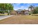 Charming tan home with stone accents, a two-car garage, fountain, and a well-manicured lawn at 7973 Lake Nellie Rd, Clermont, FL 34714