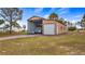 Large metal garage perfect for RV, boat, or camper storage with concrete driveway and lush green grass at 7973 Lake Nellie Rd, Clermont, FL 34714