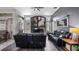Cozy living room with fireplace, mantle, dark wood flooring and comfortable black furniture at 7973 Lake Nellie Rd, Clermont, FL 34714
