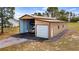 Versatile outbuilding featuring covered parking, a garage door, and extra storage space for vehicles or equipment at 7973 Lake Nellie Rd, Clermont, FL 34714