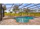Inviting screened pool and spa with brick surround, overlooking a spacious, grassy backyard and mature trees at 7973 Lake Nellie Rd, Clermont, FL 34714