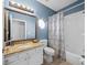 Bright bathroom with granite countertop, decorative mirror, octagon window, and shower-tub combo at 9027 Saint Andrews Way, Mount Dora, FL 32757