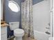Cozy bathroom with blue walls, white tiles, and patterned shower curtain at 9027 Saint Andrews Way, Mount Dora, FL 32757