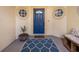 Up-close image of a blue front door flanked by round windows and a patterned rug at 9027 Saint Andrews Way, Mount Dora, FL 32757
