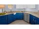 Bright kitchen features granite countertops, blue cabinets, stainless steel appliances, and tile flooring at 9027 Saint Andrews Way, Mount Dora, FL 32757
