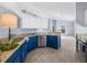 Stylish kitchen featuring granite countertops, blue cabinets, stainless appliances, and tile floors at 9027 Saint Andrews Way, Mount Dora, FL 32757