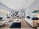 Bright living room with natural light, modern furniture, and an open floor plan flows to the kitchen at 9027 Saint Andrews Way, Mount Dora, FL 32757