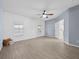 The spacious main bedroom offers two windows, wood panel accent wall, ceiling fan, and tile flooring at 9027 Saint Andrews Way, Mount Dora, FL 32757