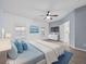 Spacious main bedroom featuring wood panel accent wall, ceiling fan, and tile flooring at 9027 Saint Andrews Way, Mount Dora, FL 32757
