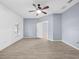 A large main bedroom featuring tile flooring, a ceiling fan, and wood panel accent wall at 9027 Saint Andrews Way, Mount Dora, FL 32757