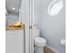 Bright powder room features granite countertop, wood-look tile floor, and octagon-shaped window for lots of natural light at 9027 Saint Andrews Way, Mount Dora, FL 32757