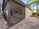 View of the screened patio with a lush backyard and tropical palm trees at 9027 Saint Andrews Way, Mount Dora, FL 32757