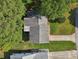 Overhead view of a home displaying roof, backyard, and driveway surrounded by lush green trees and lawn at 915 Sutherland Ct, Leesburg, FL 34788