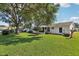 Large grassy backyard with mature trees and manicured shrubbery at 915 Sutherland Ct, Leesburg, FL 34788