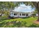 Large lawn, mature trees, and a screened-in porch complete the backyard at 915 Sutherland Ct, Leesburg, FL 34788