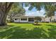 Well-maintained backyard featuring green grass and mature trees, perfect for outdoor activities at 915 Sutherland Ct, Leesburg, FL 34788