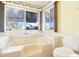 Bright bathroom featuring a large bathtub with two windows and a comfortable toilet at 915 Sutherland Ct, Leesburg, FL 34788