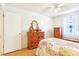 Well-lit bedroom with hardwood floors and ample dresser storage space, creating a comfortable atmosphere at 915 Sutherland Ct, Leesburg, FL 34788