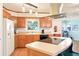 Kitchen featuring light wood cabinets, island and stainless steel hood at 915 Sutherland Ct, Leesburg, FL 34788