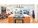 Kitchen featuring light wood cabinets and island with cooktop and dining area at 915 Sutherland Ct, Leesburg, FL 34788