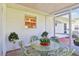 Enclosed patio featuring a glass table and wicker chairs with floral cushions at 915 Sutherland Ct, Leesburg, FL 34788